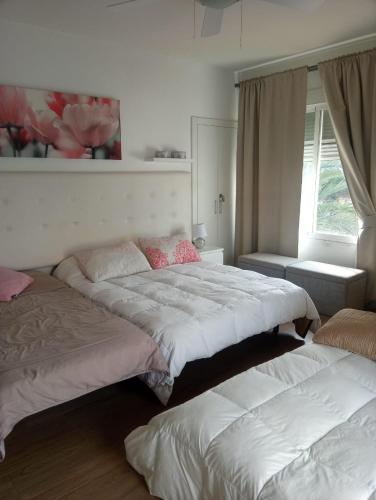 sypialnia z 2 łóżkami i oknem w obiekcie Chalet Urbanización Alcolea w Kordobie