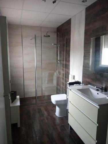 a bathroom with a toilet and a sink and a shower at Chalet Urbanización Alcolea in Córdoba