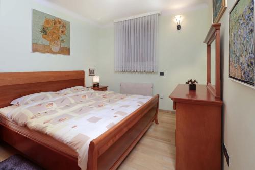 ein Schlafzimmer mit einem großen Bett und einem Schreibtisch in der Unterkunft Apartment Dante Alighieri in Opatija