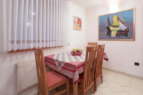 ein Esszimmer mit einem Tisch, Stühlen und einem Gemälde in der Unterkunft Apartment Dante Alighieri in Opatija