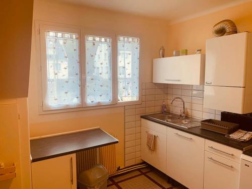 Grand appartement au calme 2 chambres في كامبار: مطبخ فيه مغسلة ونافذة