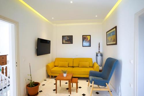 a living room with a yellow couch and a tv at Fira Central Apartments with Veranda in Fira