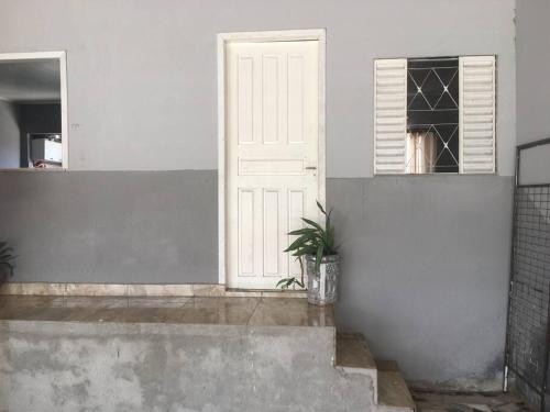 a white door and a potted plant in a room at Suíte próximo ao Shopping in Rio Branco