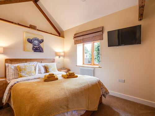 a bedroom with a bed and a tv on the wall at The Parlour - Uk10958 in Burlton