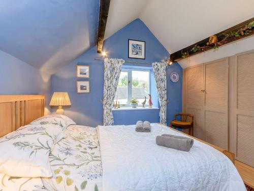 um quarto com paredes azuis e uma cama grande em The Smithy - E5445 em Brassington