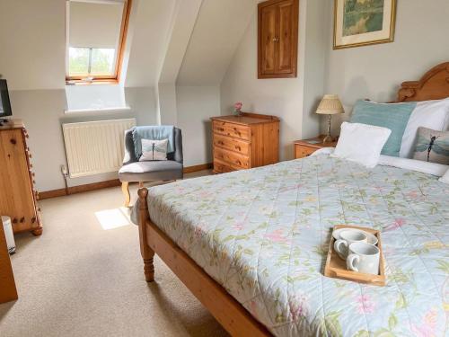a bedroom with a bed with a tray of dishes on it at The Lodge in Thakeham