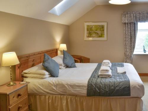a bedroom with a bed with two towels on it at The Mill House in Warenford