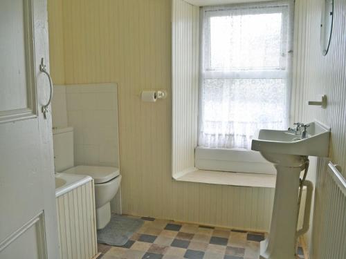 a bathroom with a sink and a toilet and a window at Seagulls in Holyhead