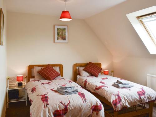 two twin beds in a room with a attic at Kimberley Apartment in Alness
