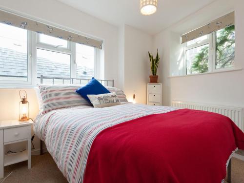 a bedroom with a large bed and two windows at College View 2 Upper in Kingswear