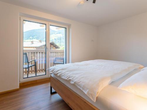 a bedroom with a bed and a large window at Villa Felding Top 3 in Bad Hofgastein