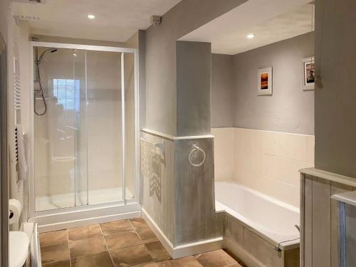 La salle de bains est pourvue d'une douche et d'une baignoire. dans l'établissement Liam Cottage - Cv13, à Saint Cleer