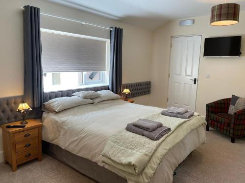 a bedroom with a bed with a window and a chair at The Old Kitchen -uk32062 in Burwarton