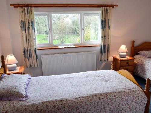 a bedroom with a bed and a window at Copper Beech in Netherbury