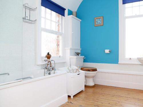 a bathroom with a tub and a toilet and a window at Hamilton House in Royal Tunbridge Wells
