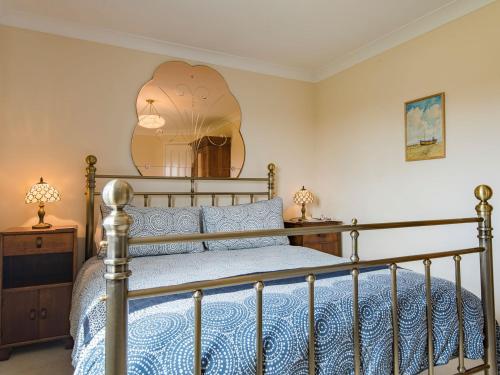 een slaapkamer met een bed en een grote spiegel bij Helvetia in Dungeness