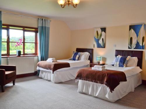 una camera d'albergo con due letti e un lampadario a braccio di Brynich Villa a Brecon