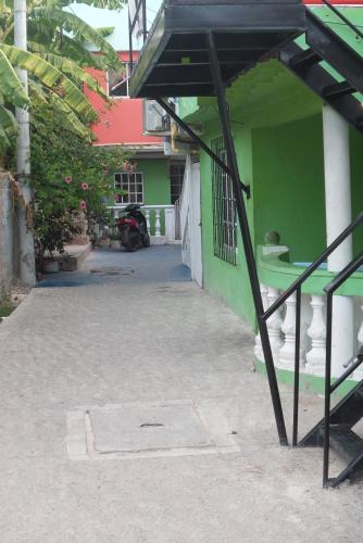a green and white building with a staircase in front at Posada J&J Forbes - 2 in San Andrés