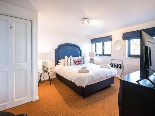 a bedroom with a large bed with a blue headboard at Peakaboo in Sidmouth