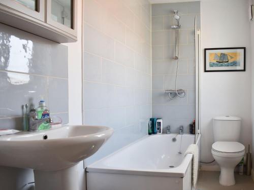 a bathroom with a sink and a tub and a toilet at Blue Cottage in Broadstairs