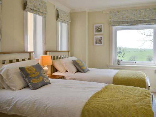 two beds in a room with two windows at Yonderton Mcgill Cottage - Uk11182 in Hollybush