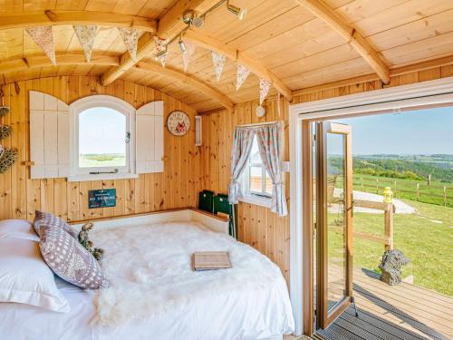 ein Schlafzimmer mit einem großen Bett in einem Holzhaus in der Unterkunft Nirvana in Stoodleigh