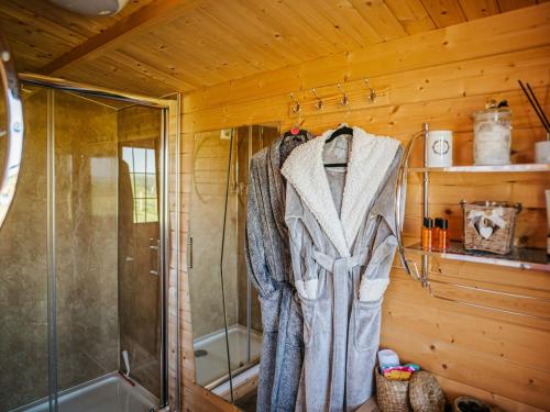 a bathroom with a shower and a robe hanging on a wall at Nirvana in Stoodleigh