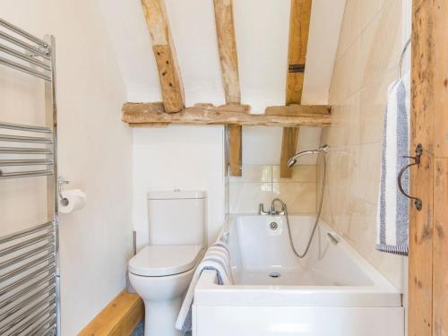 a bathroom with a toilet and a bath tub at Norwood Barn in Maidstone