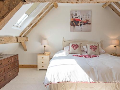 a bedroom with a large white bed and a dresser at Norwood Barn in Maidstone