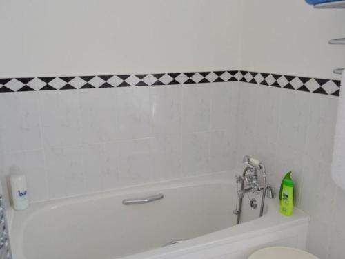 a bathroom with a white tub and a toilet at Roadstead in Fowey