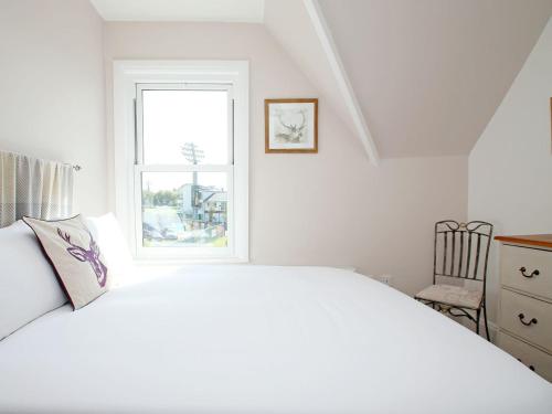 a white bedroom with a bed and a window at Skyfall in Canterbury