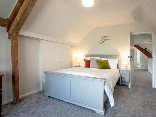 a bedroom with a white bed in a attic at The Old Farmhouse in Chardstock