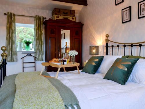 a bedroom with a large bed and a table at The Lodge in Dyserth