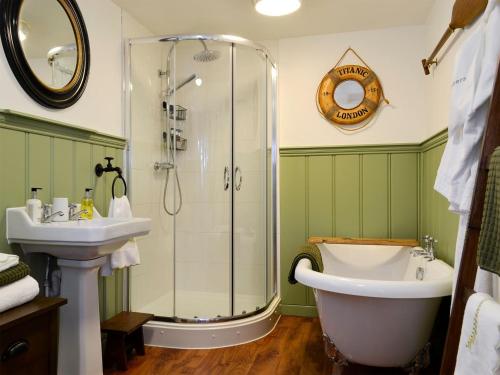 a bathroom with a shower and a tub and a sink at The Lodge in Dyserth