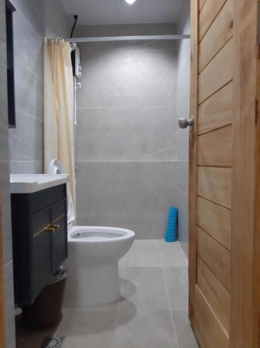 a bathroom with a toilet and a sink and a shower at M LILOAN PENSION HOUSE in Catarman