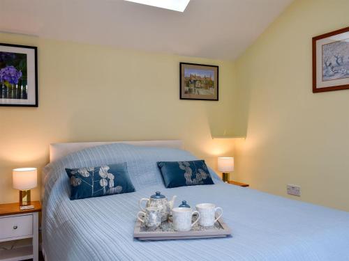 a bedroom with a bed with a tray with tea sets on it at The Annexe in Barham