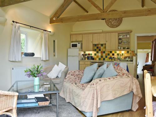 a bedroom with a bed and a table and a kitchen at The Old Forge in Cattistock