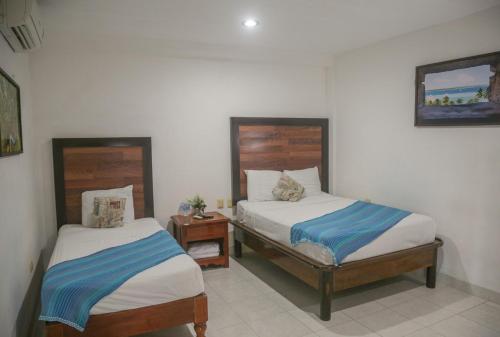 una camera con 2 letti, un comodino e sidx sidx sidx sidx di Seven Blue House Village & Lodge a Bacalar