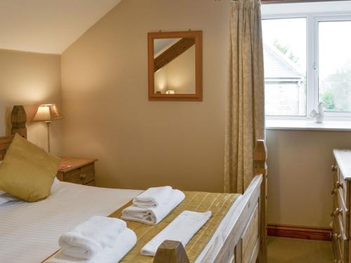 1 dormitorio con 1 cama con toallas en Waren View, en Warenford