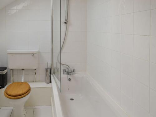 y baño blanco con aseo y ducha. en Waren View, en Warenford
