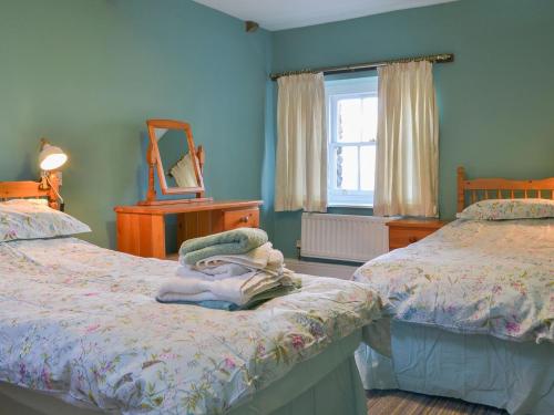 a bedroom with two twin beds and a mirror at Eamont - NP2802 in Dockray