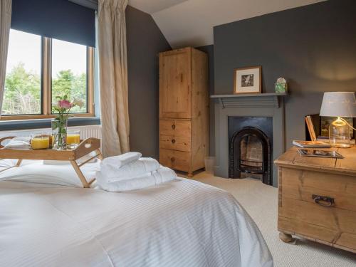 a bedroom with a white bed and a fireplace at Station Lodge in Stretton on Fosse