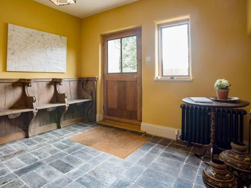 a room with yellow walls and a door and a table at Station Lodge in Stretton on Fosse