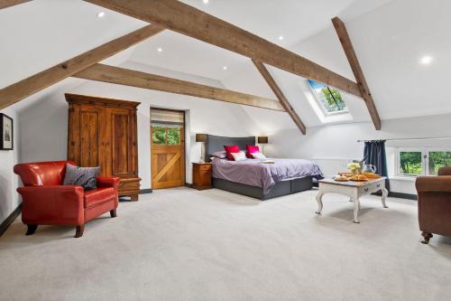 a bedroom with a bed and a red chair at The Coach House in Blaenporth