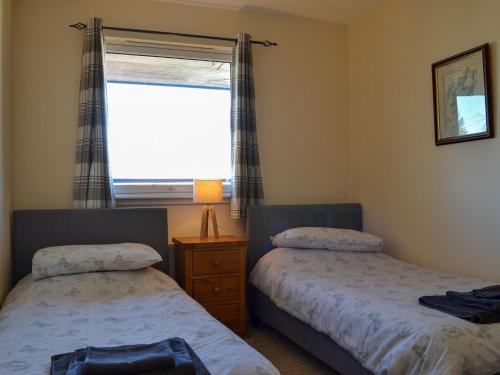 sypialnia z 2 łóżkami obok okna w obiekcie Ness-side Apartment w mieście Inverness