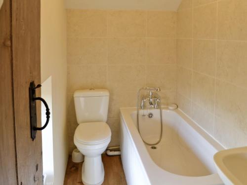 a bathroom with a toilet and a tub and a sink at Beckside in Bellerby