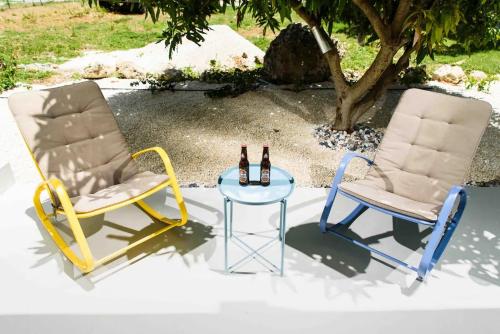 two chairs and a table with two bottles of beer at Coconut Breeze 2 in Saint Philip
