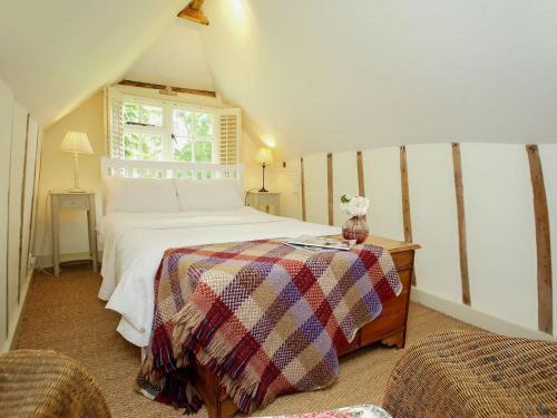 a bedroom with a white bed and a window at Prospect Cottage in Wittersham