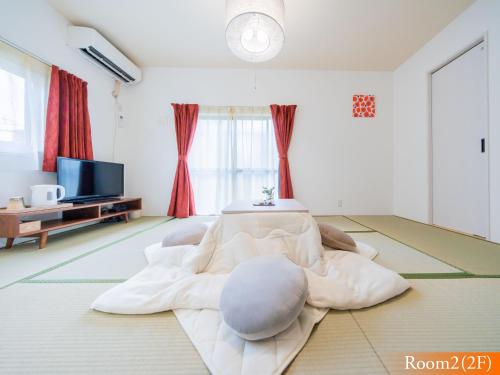 sala de estar con sofá blanco y TV en 波奈 浅草 Hana Asakusa ーSkyTree前駅まで徒歩5分ー, en Tokio