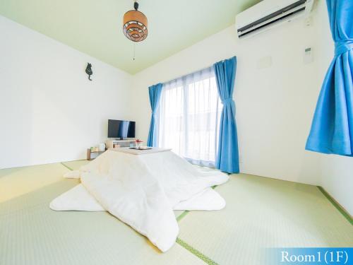 a room with a bed and a window with blue curtains at 5min walk to Tokyo Skytree Sta -HANA ASAKUSA- in Tokyo